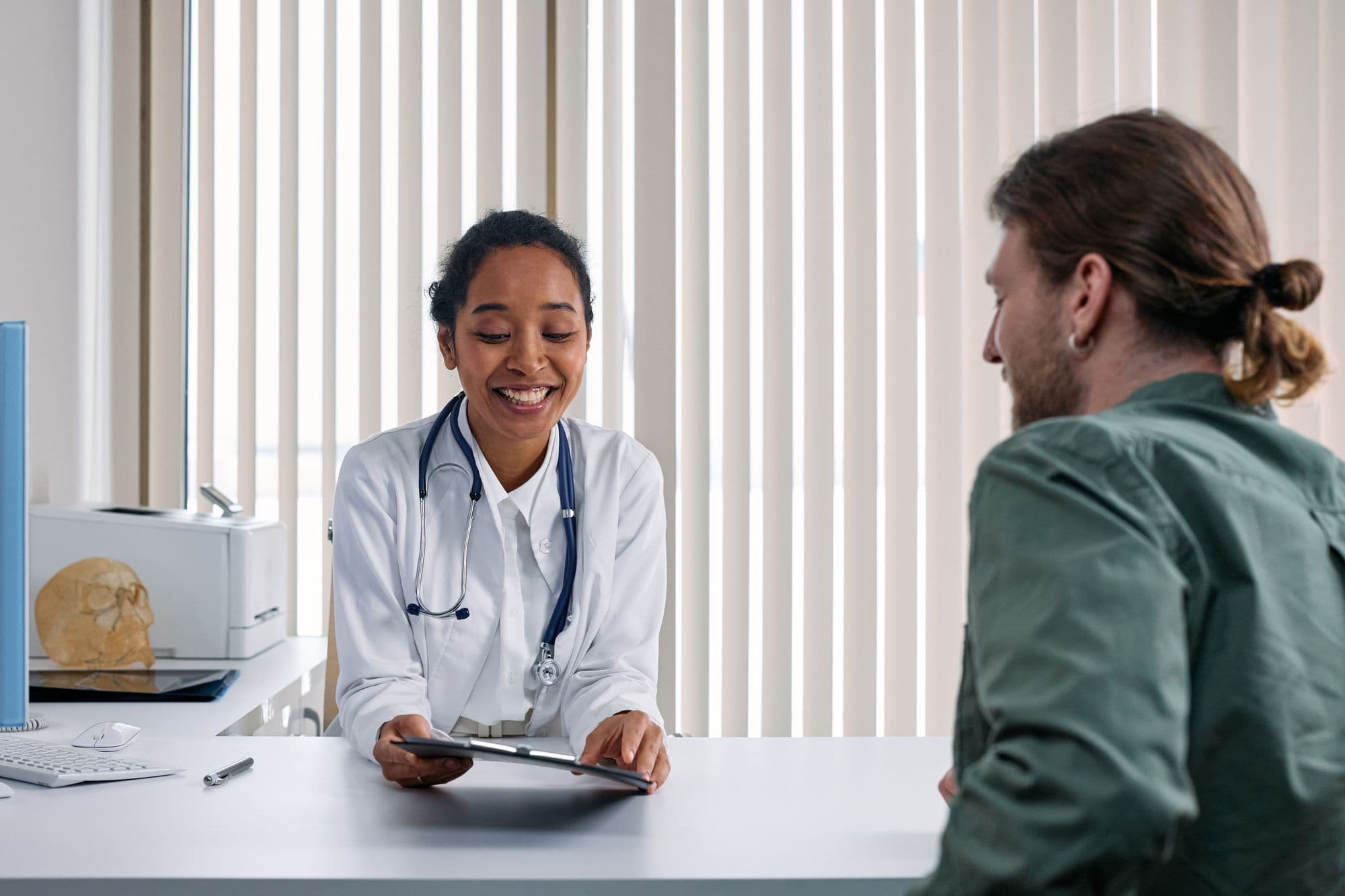 A doctor in a white coat consulting a patient in a bright clinic